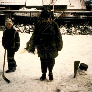 Two people clearing snow with shovels in winter.