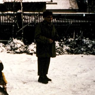 People clearing snow-covered ground with shovels.