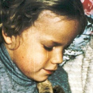 A child and cat sharing a cozy indoor moment.