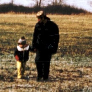 Family walking by lake in rural countryside.