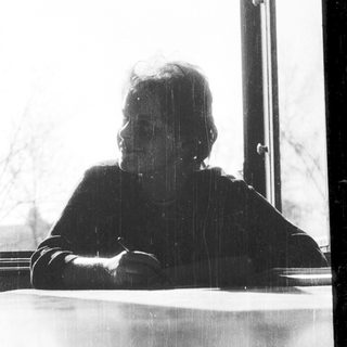 Person sitting alone by a window.