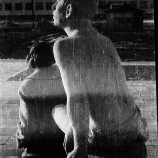 Sculpture of seated, contemplative nude figure.