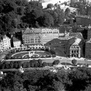 Aerial view of historic urban buildings and gardens.