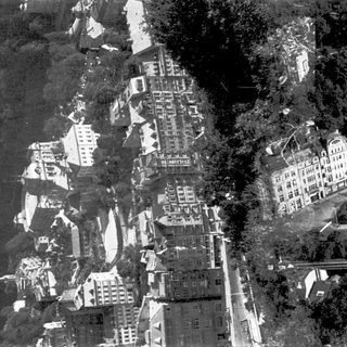Aerial view of historic European town nestled in hilly terrain.