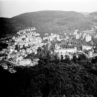 Historic town nestled in hilly, forested landscape.