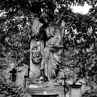 Elegant tomb monument with angelic statue in cemetery.