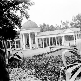 Elegant pavilion in landscaped garden with greenery.