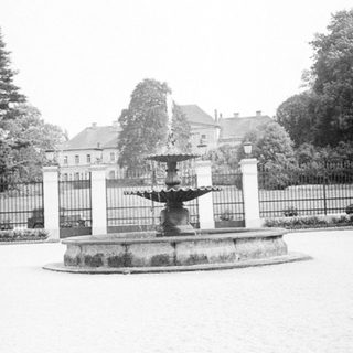 Classic fountain in landscaped park area.