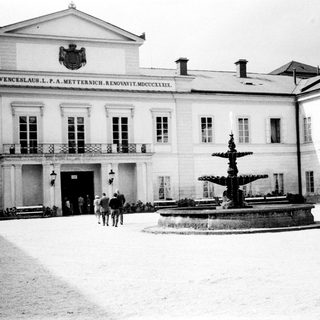 Neoclassical building with Metternich inscription and fountain.