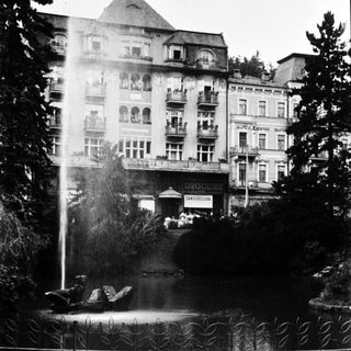 Elegant historic hotel with fountain in foreground.