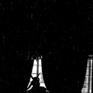 Silhouette of Eiffel Tower against dark sky.