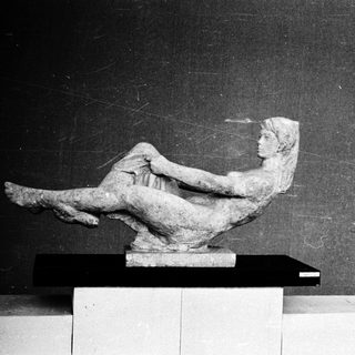 Reclining classical female figure sculpture.