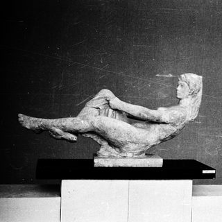 Reclining classical female figure sculpture.