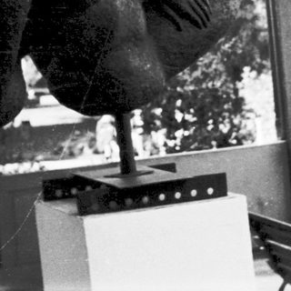 A person mid-air performing a handstand indoors.