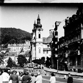 People viewing historic town with prominent church.