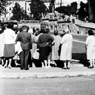 People viewing historic town with prominent church.