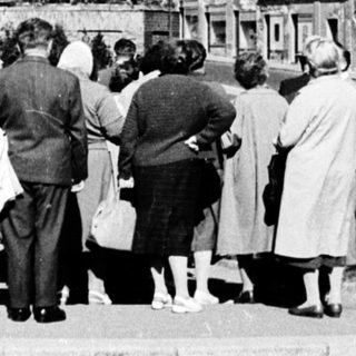 People viewing historic town with prominent church.