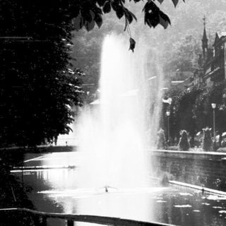 Historic fountain in urban park setting.