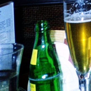 Young child sitting at restaurant table with drink.