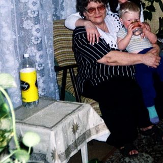 Family moment with grandmother, woman, and baby indoors.