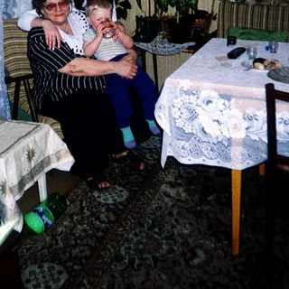 Family moment with grandmother, woman, and baby indoors.