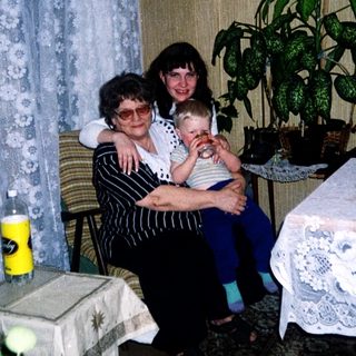 Family moment with grandmother, woman, and baby indoors.