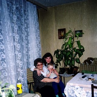 Family moment with grandmother, woman, and baby indoors.