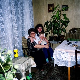 Family moment with grandmother, woman, and baby indoors.