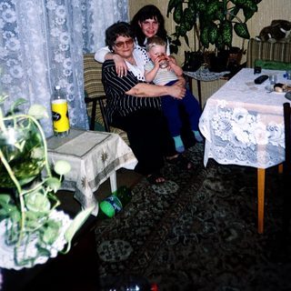 Family moment with grandmother, woman, and baby indoors.