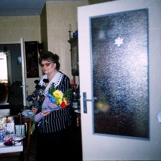 Woman speaking at a celebratory indoor gathering with gifts.