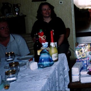 Woman speaking at a celebratory indoor gathering with gifts.