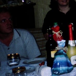 Woman speaking at a celebratory indoor gathering with gifts.