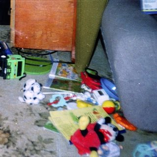 Child sitting on toy wagon indoors.