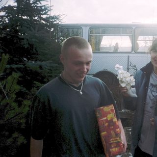 Two people holding flowers and gift bags.