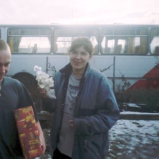 Two people holding flowers and gift bags.