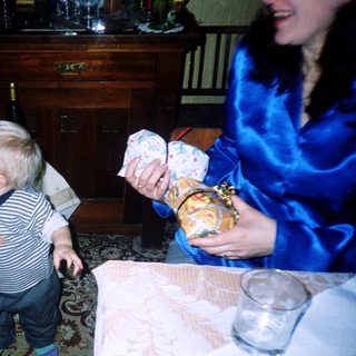 Toddler reaching for food at table.