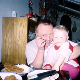 A man and child sharing dessert indoors.