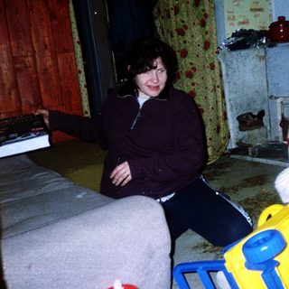 Woman sitting with smiling child in yellow toy.