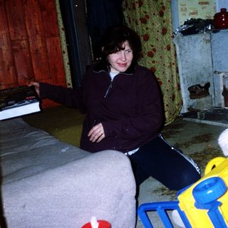 Woman sitting with smiling child in yellow toy.