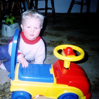 Young child playing with toy truck indoors.