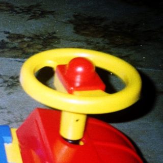 Young child playing with toy truck indoors.