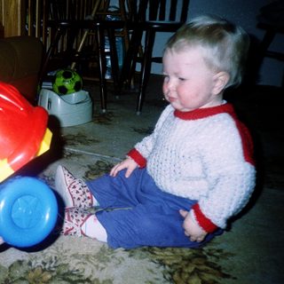 Young child playing with colorful toy car.
