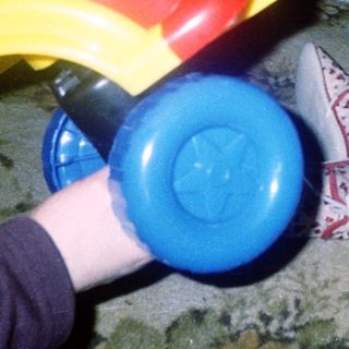 Young child playing with colorful toy car.