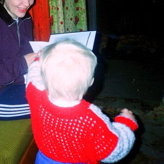 Woman reading to a young child indoors.