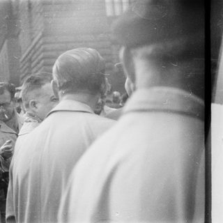 Men participating in a religious procession carrying a statue.