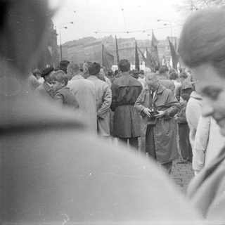 Historical street protest with flag-bearing marchers.