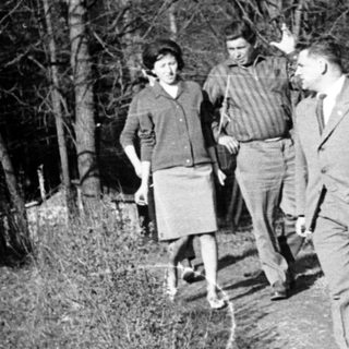 Three men walking on a forest path.