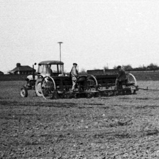 Vintage tractor plowing open field.