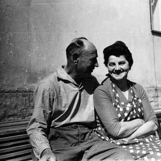 Happy elderly couple sitting together outdoors.