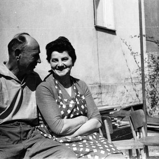 Happy elderly couple sitting together outdoors.